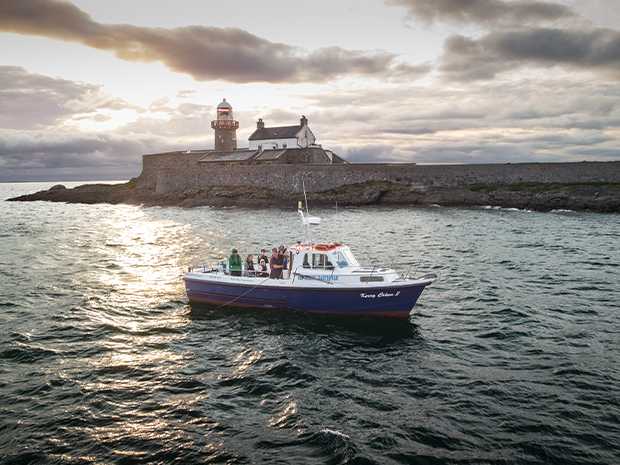 Boat in front of Fenit Lighthouse